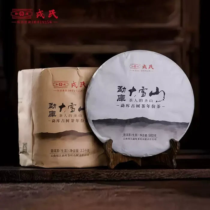 Chinese puerh tea cake and paper-wrapped tea, pressed tea disc on wooden stand, traditional packaging