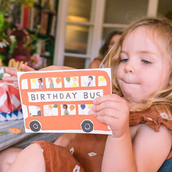 Child looking inside of the birthday bus  card at a celebration