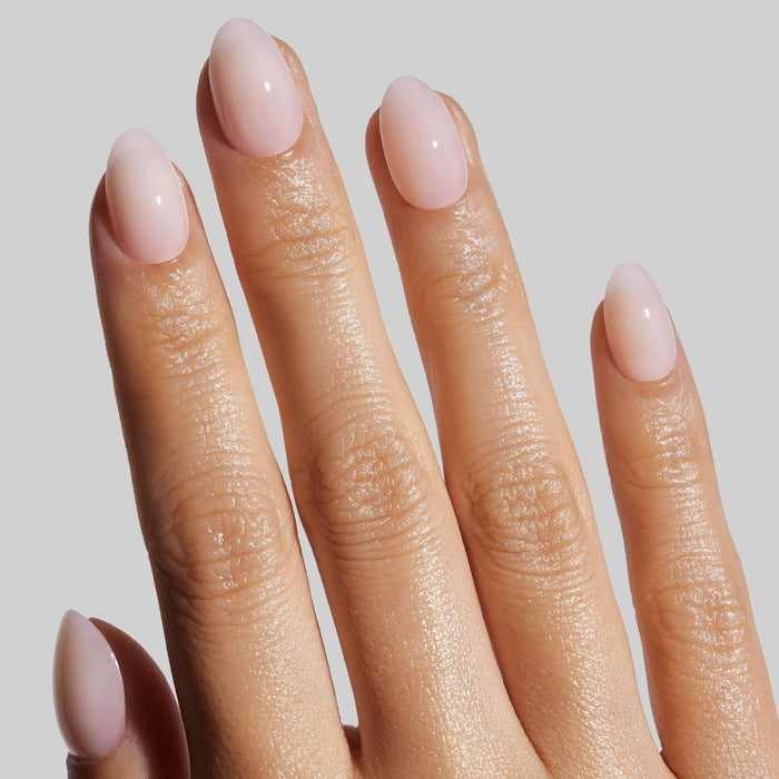 Coconut Milk almond press-on nails worn on model's hand, showcasing nude pink manicure