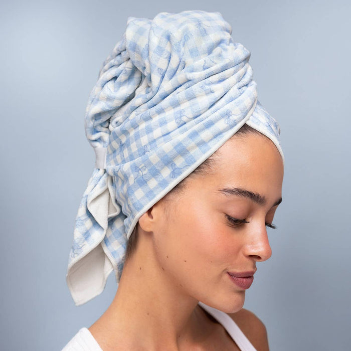 Woman wearing blue gingham XL hair towel wrap on wet hair against neutral background