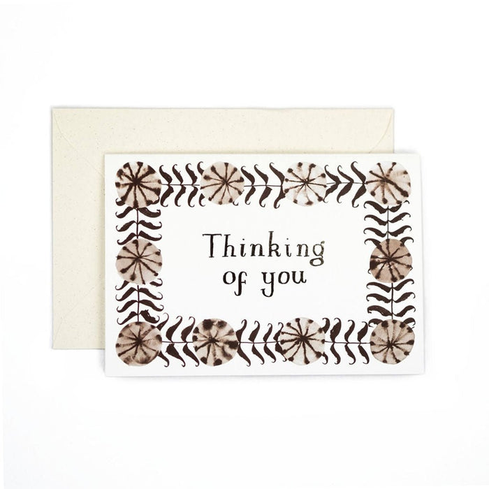 Greeting card reading “Thinking of you” with a brown botanical border, shown with a cream envelope.